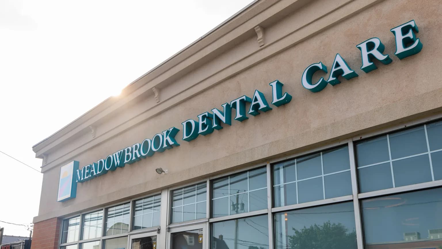 Exterior of the Meadowbrook Dental Care office on East Jericho Turnpike in Mineola, NY, with the practice name on the storefront sign