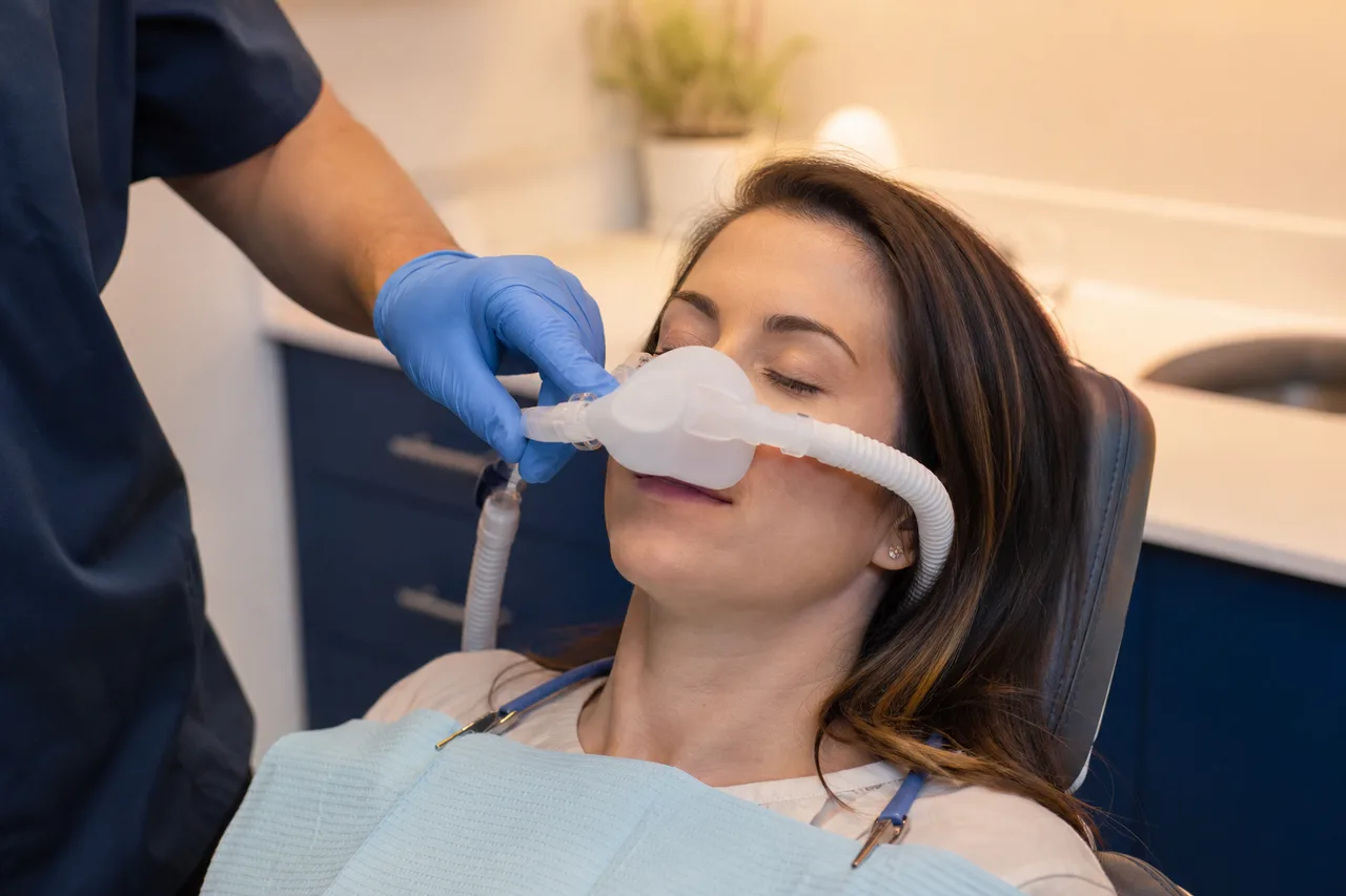 Patient relaxing with a nasal mask for nitrous oxide sedation in a modern dental operatory